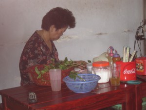 Kvinne som renser grønnsaker/urter.